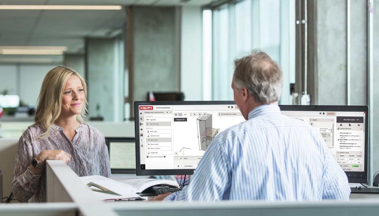 Woman sitting at desk in conversation with a Hilti Engineer
