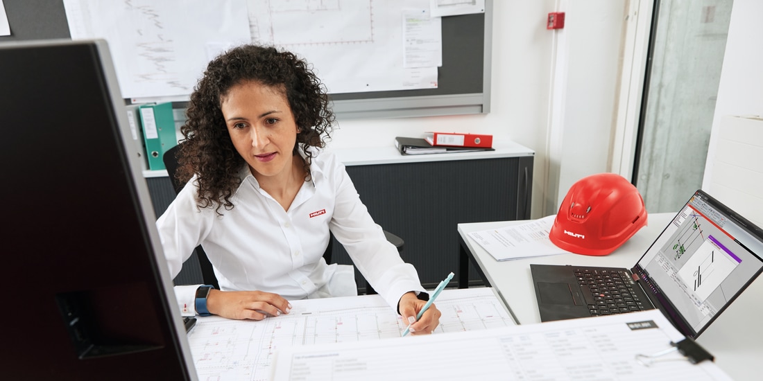 Hilti engineer onsite with a customer with shop drawings in the foreground