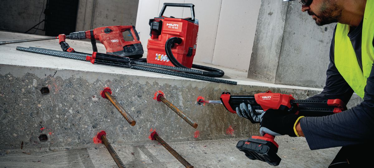 Jobsite worker injecting RE 500 with cordless dispenser HDE 500-22 into concrete for rebar installation