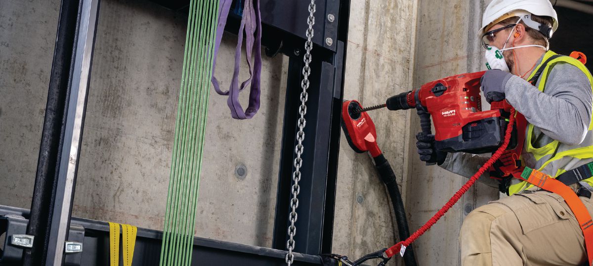 Drilling in elevator shaft with powerful SDS-Max combihammer, with drop prevention tethering solution and dust removal DRS-D.