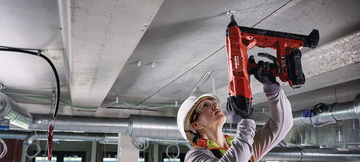 Cropped application picture of construction worker doing roof overhead application on the floor using the BX4-22 with the B22-85 battery
