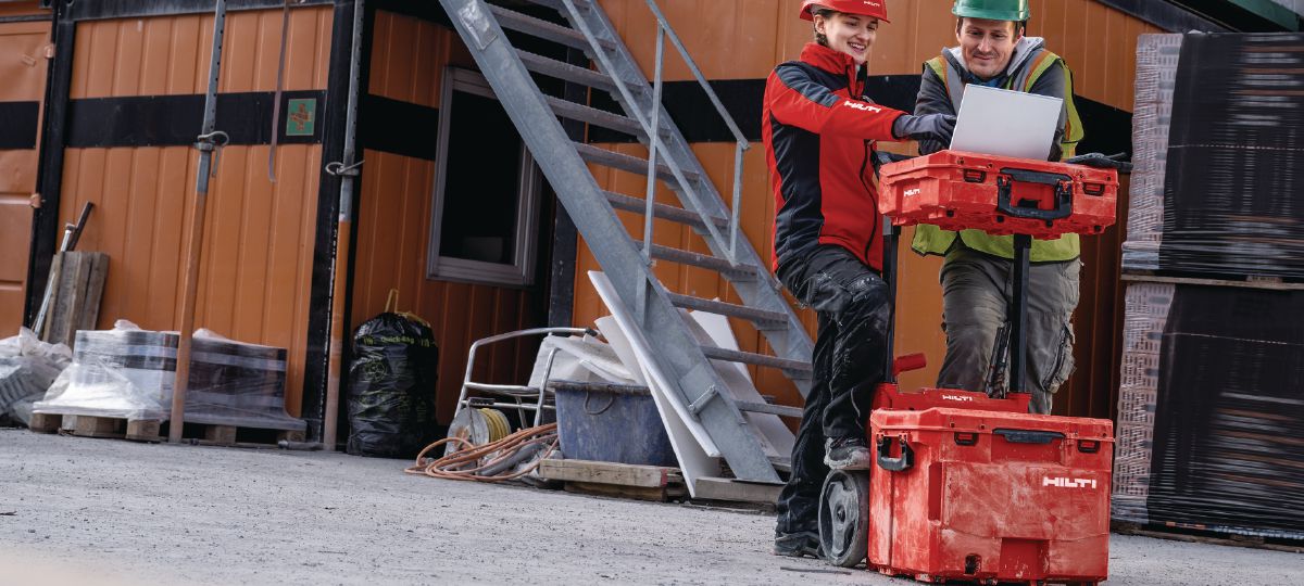 Cropped application picture of two workers using the ProKit Modular Storage System as a base for their laptop.