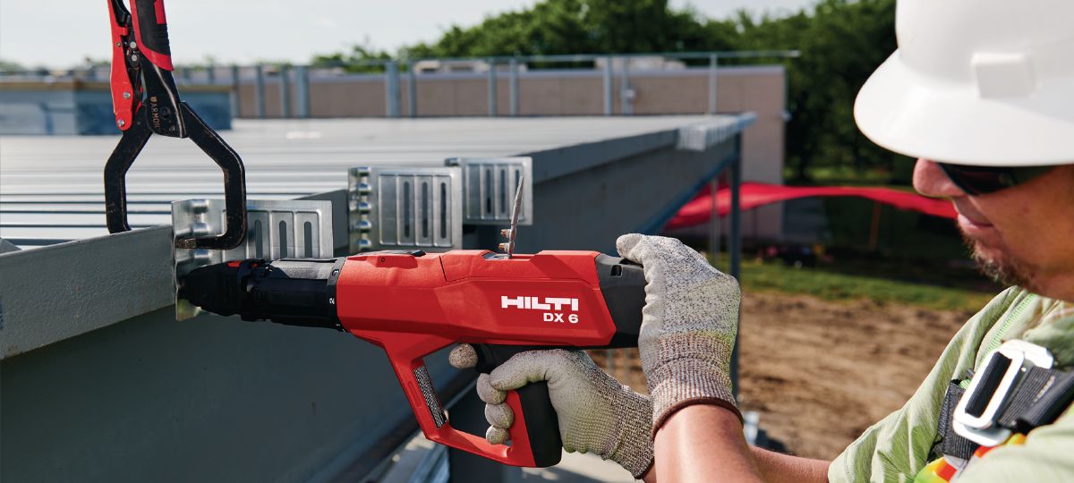 DX 6 with P8 Piston assy, application on a jobsite. Worker in a lift installing deflection clips with X-U 16 pins. (HNA)