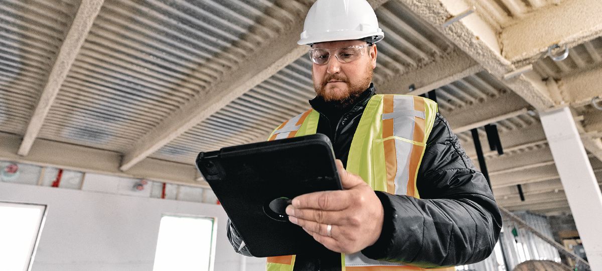 Cropped  image of operations manager on a jobsite looking at a tablet.